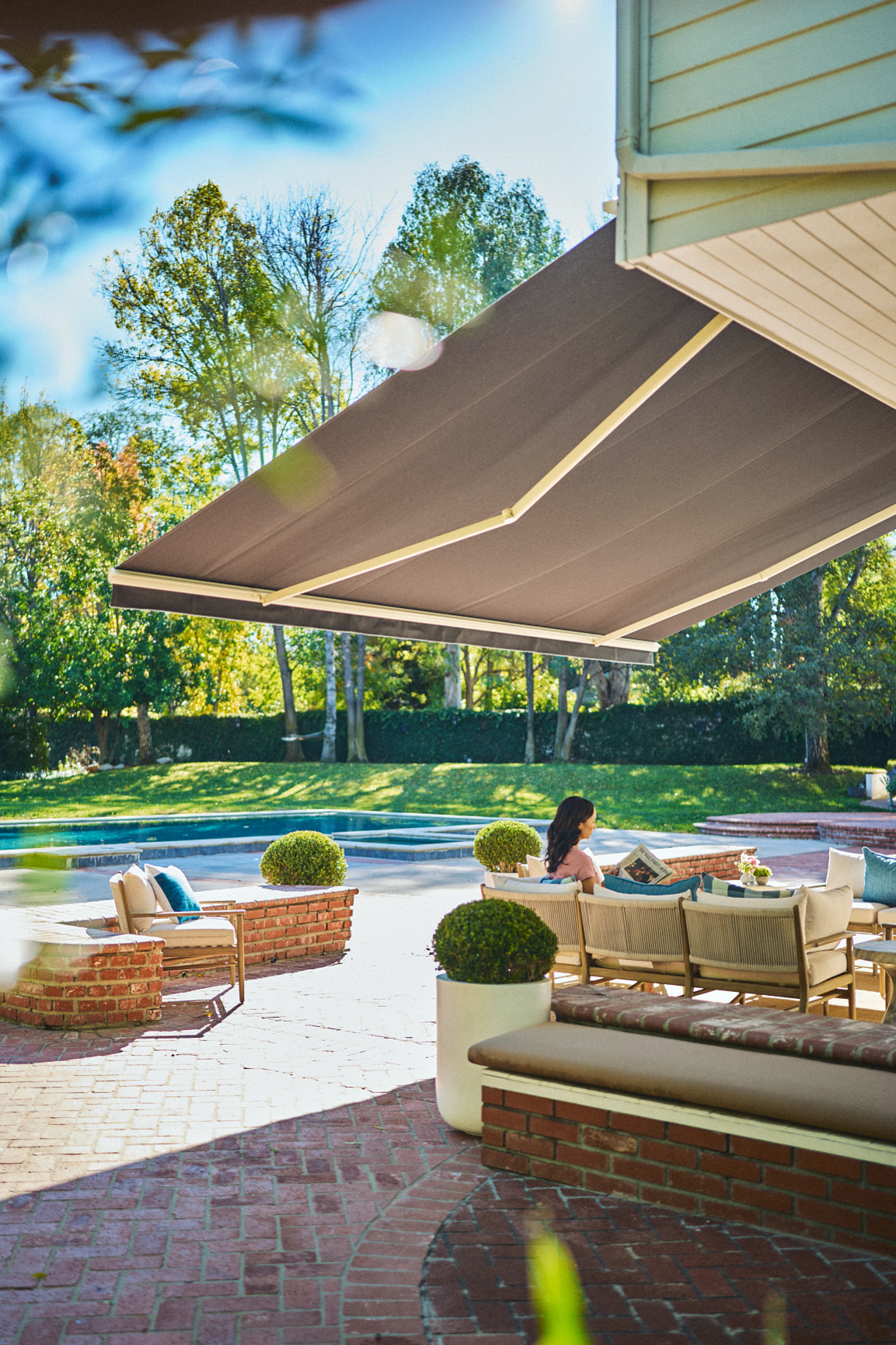 Retractable awning with integrated lighting over a poolside patio